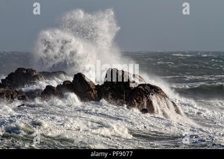 De grosses vagues se briser contre les rochers dans un après-midi venteux Banque D'Images