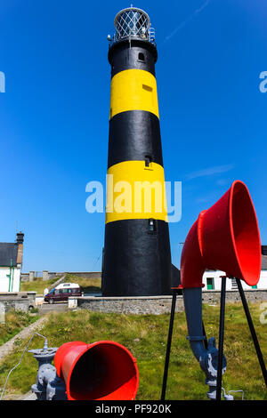 Phare noir et jaune avec des cornes de brume rouge en premier plan. St John's Point Lighthouse, comté de Down, Irlande du Nord. Banque D'Images