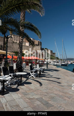 La promenade remplie de restaurants donnant sur la marina et à proximité de la citadelle de Calvi, sur la côte nord-ouest de la Corse, France. Calvi est renommée Banque D'Images