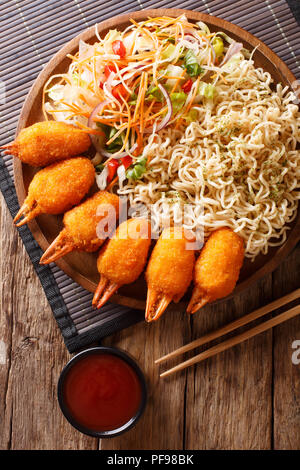 Faites frire pinces de crabe, les nouilles Udon et salade de légumes frais sur une assiette sur la table. Haut Vertical Vue de dessus Banque D'Images