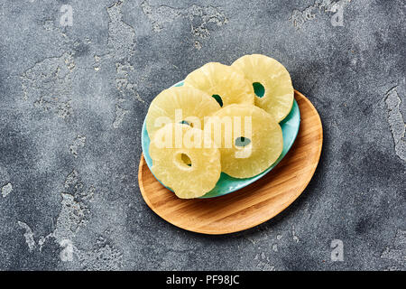 Ananas séché bagues sur un tableau gris. Haut viw de paneapple doux tranches. Banque D'Images