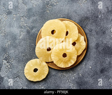 Ananas séché bagues sur un tableau gris. Haut viw de paneapple doux tranches. Banque D'Images