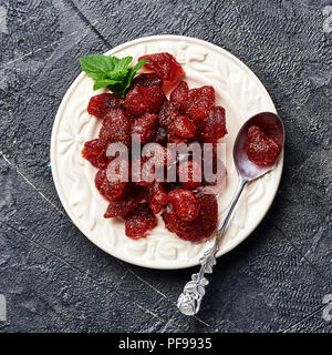 Fraises sucrées séchées sur un fond noir. Vue de dessus d'un des petits fruits confits. Banque D'Images