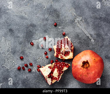 Fruits avec graines de grenade sur fond gris avec copie espace. Vue d'en haut. Banque D'Images