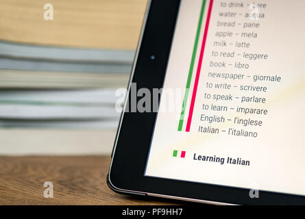 Apprendre l'italien à l'aide d'une tablette avec des livres dans l'arrière-plan. Banque D'Images