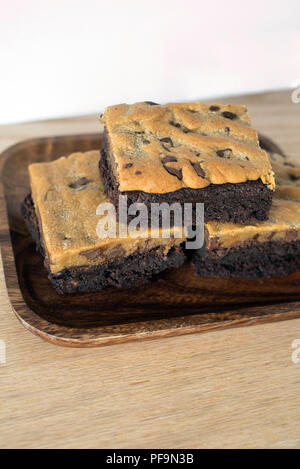 Tentant de traiter 3 Brownie Brookie Les barres empilées sur une plaque Banque D'Images