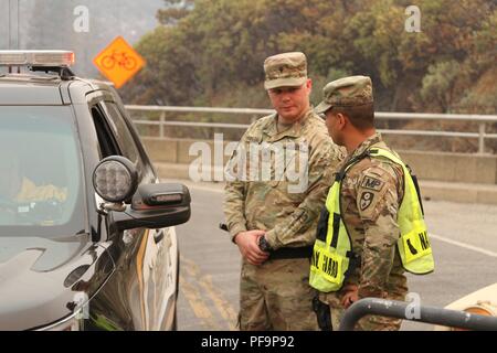 La Garde nationale de l'Armée de Californie Cameron Spc Hodges et le Sgt Jésus valence de la 270e Compagnie de Police Militaire, 185e Bataillon de la Police Militaire, 49e Brigade de police militaire, la mise à jour d'un shérif du comté de Shasta 29 Juillet au barrage de Keswick à Redding en Californie, l'un d'une douzaine de points de contrôle de la circulation dans un premier temps tenus par la police militaire sur leur première journée de travail, de l'activation, le 29 juillet 2018. Image courtoisie le s.. Edward Siguenza/Californie Garde Nationale. () Banque D'Images