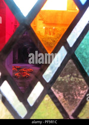 Vue rapprochée de la en forme de diamant de couleur des panneaux de verre dans le vitrail, à la recherche sur la cour ; Baddesley Clinton, Warwickshire Banque D'Images