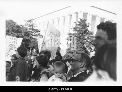 Photographie noir et blanc, montrant un groupe de personnes (y compris un couple avec un petit enfant) holding signs et marche pour protester contre la guerre du Vietnam, près de le Mémorial de Lincoln à Washington DC, United States, 1969. () Banque D'Images