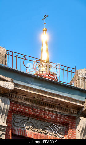 Magnifique dôme doré sur le dessus d'une croix lumineuse qui brille sous les rayons du soleil Banque D'Images