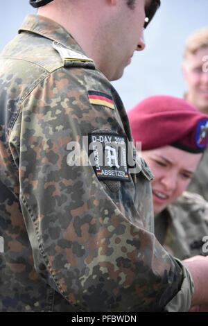 Une épaule commémorant le D-Day jump en Normandie France est porté fièrement sur l'uniforme d'un parachutiste allemand il enjoint les parachutistes alliés sur des techniques pour aller avec matériel allemand. Banque D'Images