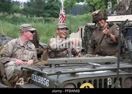 Deux scouts de cavalerie avec 2e Bataillon, 8e régiment de cavalerie de l'Armée, 1e Brigade Combat Team, l'échange de plaisanteries avec un résident local aux enfants la Journée de reconnaissance du 2 juin 2018 à Konotop, Pologne. (Michigan Army National Guard Banque D'Images