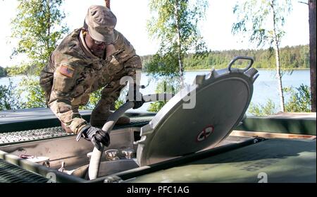 La FPC. William Brown, un spécialiste de l'approvisionnement pétrolier affecté au 226e compagnie d'approvisionnement Composite, 87e Bataillon de soutien de soutien au combat, 3e Division d'infanterie, Fort Stewart, Géorgie, utilise un flexible pour remplir un buffle avec de l'eau purifiée pendant la grève 18 Sabre sur base de Adazi, la Lettonie, le 6 juin 2018. Grève de sabre est un exercice multinational en ce moment à sa huitième année. L'exercice de cette année est prévue pour la période de juin 3-15 et permet aux participants de 19 pays de s'entraîner ensemble et d'améliorer les unités chaque capacité de remplir leurs missions. désignés Banque D'Images