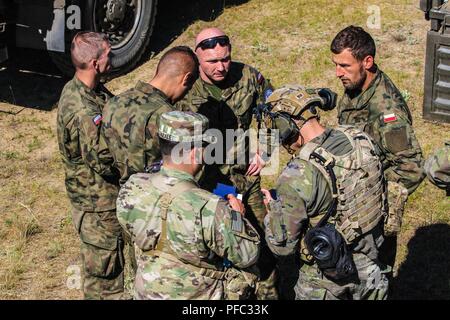 Un groupe composé d'un parachutiste du 1er groupe de reconnaissance à long rayon d'espagnol, un observateur/coach/contrôleur de l'United States Army's Centre de préparation interarmées multinationale, et les membres d'une unité de transport à partir de la 6e Brigade aéroportée un dernier coordonner contrôler avant de passer à l'objectif suivant après l'insertion 5 juin 2018. Cet événement de formation a eu lieu pendant la grève de sabre 18, une Europe de l'armée américaine a conduit à l'exercice de la promotion de la sécurité et de la stabilité tout en renforçant les capacités des partenaires dans la région baltique. La Garde Nationale (Michigan) Banque D'Images