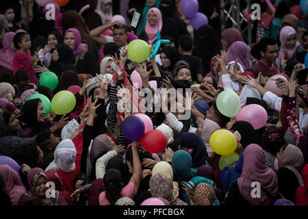 Le Caire, Égypte. Août 21, 2018. Les gens essaient d'attraper des ballons mis en libre après l'Aïd al-Adha prières, au Caire, Égypte, 21 août 2018. Les musulmans du monde entier célèbrent l'Aïd al-Adha, qui marque le Hajj pèlerinage à la ville sainte de La Mecque, en abattant les animaux sacrificiels en commémoration du Prophète Abraham est prêt à sacrifier son fils pour montrer l'obéissance à Dieu. Credit : Gehad Hamdy/dpa/Alamy Live News Banque D'Images