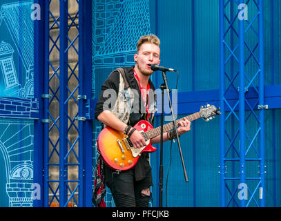 Edinburgh Fringe, Édimbourg, Écosse, Royaume-Uni. 21 août 2018. Virgin Money parrainé street sur le Royal Mile, dans la dernière semaine de la Fringe Festival. Un chanteur guitariste solo joue sur l'un des stades temporaires Banque D'Images