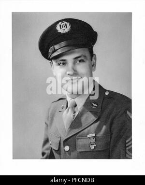 Photographie noir et blanc, montrant un portrait officiel d'un homme soldat, à l'appareil photo, avec un très léger sourire sur son visage, le port d'un uniforme avec une broche sur le revers de la Force aérienne, une médaille et un capuchon avec une bande armée américaine insignia, probablement photographié dans l'Ohio pendant la Seconde Guerre mondiale, 1945. () Banque D'Images