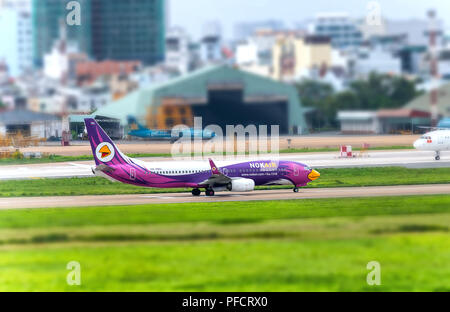 Avion de passagers Boeing 737 de Nok Air survoler les zones urbaines se préparer à l'atterrissage à l'Aéroport International de Tan Son Nhat Banque D'Images