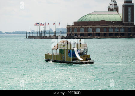 Un bateau de partie flotte par le Navy Pier à Chicago, Illinois. Banque D'Images