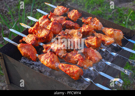 La viande de cuisson en plein air. Juteux délicieux grillés en brochettes de viande marinée dans jardin, vue de dessus, close-up Banque D'Images