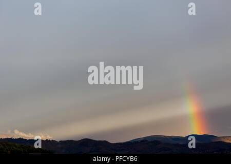 Belle et surréaliste vue d'une partie d'un arc-en-ciel sur certaines collines Banque D'Images