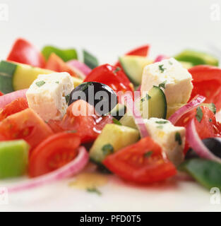 Partie de la salade grecque, concassé de tomates, concombres, fromage feta, oignon rouge, olives noires, vinaigrette d'huile, saupoudrées de fines herbes Banque D'Images