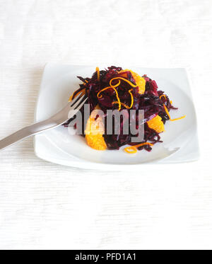 Composé de salade sauté de chou rouge et les tranches d'orange, sur une assiette, la fourchette Banque D'Images