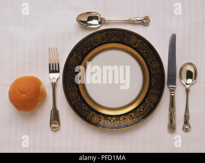 Ensemble de salle à manger élégante composée d'assiette, fourchette, couteau, deux cuillères, et un rouleau blanc. Banque D'Images