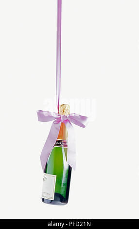 Bouteille de Champagne se balançant d'un ruban rose Banque D'Images