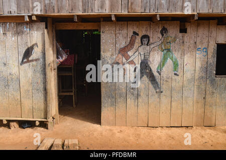 Un style Bruce Lee Kung Fu lutte murale scène peinte sur un bâtiment en bois dans la forêt amazonienne, près de Lima, Pérou Banque D'Images