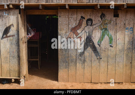 Un style Bruce Lee Kung Fu lutte murale scène peinte sur un bâtiment en bois dans la forêt amazonienne, près de Lima, Pérou Banque D'Images