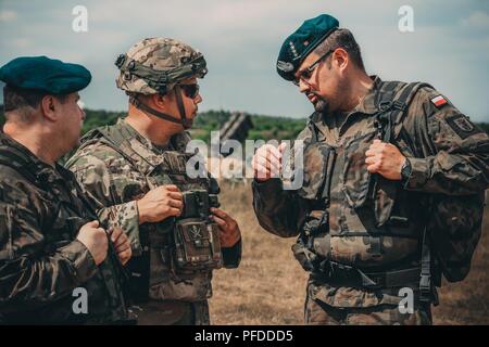 L'Adjudant-chef de l'armée américaine 2 Eric Terre, centre, affecté à la 5e Bataillon, 7e Régiment de défense aérienne de l'Air polonaise informe les officiers d'artillerie de défense des points saillants de la MIM-104 Patriot nouveau système de missiles sol-air près de Drawsko Pomorskiego, Pologne, le 4 juin 2018. N'ayant jamais été avant ce proche d'un militaire américain et patriote de défense antimissile avant, les forces terrestres polonaises ont pris à l'occasion de poser des questions concernant les nouveaux systèmes de capacités. Banque D'Images