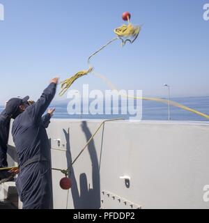 Le Pirée, Grèce (4 juin 2018) Maître de Manœuvre Seaman Austin Burns, de Murrieta, Californie, lance une ligne d'attrape flottante de la fo'c'sle de la San Antonio-classe de transport amphibie Navire dock USS New York (LPD 21) que le navire arrive à le Pirée, Grèce, pour une escale prévue le 4 juin 2018. New York, homeported à Mayport, en Floride, mène des opérations navales dans la sixième flotte américaine zone d'opérations à l'appui de l'intérêt de la sécurité nationale des États-Unis en Europe et en Afrique. Banque D'Images