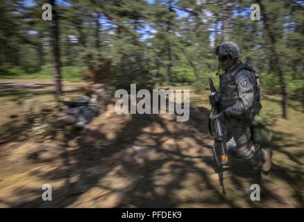 Un soldat de la Garde nationale de l'Armée américaine du New Jersey's 250e Détachement des finances exécute pour couvrir pendant la formation sur Joint Base McGuire-Dix-Lakehurst, N.J., le 5 juin 2018. Le 250e Détachement des Finances a reçu une formation en défense de base par des instructeurs de l'armée américaine 174e Brigade d'infanterie. Banque D'Images