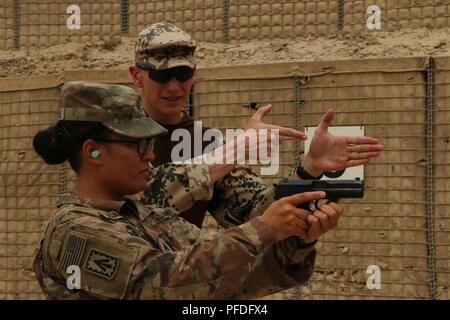 L'AÉRODROME DE BAGRAM, en Afghanistan (10 juin 2018) -- Le Lieutenant-colonel de l'armée allemande Jens Janis (droite), officier de liaison avec le Train, conseiller et assister les Command-North, affecté à l'appui résolu de l'OTAN, la Mission explique la bonne prise en main et les techniques de tir de l'Heckler and Koch P8 pistolet de service allemand de l'armée américaine pour le Sgt. Luafulu Amanda, un sous-officier affecté à la formation à la Batterie B, 2e Bataillon, 44e Régiment d'artillerie de défense aérienne des États-Unis, Forces-Afghanistan, Juin 10. Janis chargé d'environ 50 membres du service sur l'utilisation appropriée de la P8 pistolet de service et de l'Heckler and Koch G36, fusil Banque D'Images