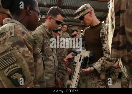 L'AÉRODROME DE BAGRAM, en Afghanistan (10 juin 2018) -- Le Lieutenant-colonel de l'armée allemande Jens Janis (droite), officier de liaison avec le Train, conseiller et assister les Command-North, affecté à l'appui résolu de l'OTAN, la Mission explique Heckler et Koch G36 Mécanisme de libération magazine fusil de l'Armée américaine à la CPS. Nicolas Ernst, une technologie avancée de données tactiques d'artillerie de l'opérateur des systèmes affectés à la 101st Airborne Division (Air Assault) Artillerie, Forces-Afghanistan Aux États-Unis, le 10 juin, à l'aérodrome de Bagram, en Afghanistan. Janis chargé d'environ 50 membres du service sur l'utilisation appropriée de la G36 et le fusil Heckler et Koch P8 Banque D'Images