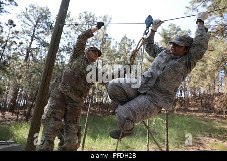 Circuit de l'armée américaine. James Smith avec la 982e compagnie de transmissions (Caméra Combat) (Airborne) aide le sergent-chef de l'US Air Force. Karin, Pastian avec le 28e Escadron de Préparation logistique à travers un obstacle dans le travail d'équipe au cours réactionnaire des dirigeants, à l'appui de Coyote d'or, Rapid City, S.D., 13 juin 2018. Le Coyote d'or l'exercice est un trois-phase, axée sur des mises en exercice mené dans les Black Hills du Dakota du Sud et le Wyoming, qui permet de se concentrer sur les commandants de mission besoins essentiels concernant la tâche, les tâches et les exercices de combat guerrier. Banque D'Images