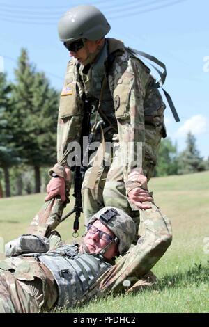 Circuit de l'armée américaine. Jonathan Cameron, 190e Bataillon de soutien au maintien en puissance de combat de la Garde nationale du Montana, de l'Armée américaine fait glisser le Sgt. 1re classe Bo Ivers, 147e du Dakota du Sud de la bande de l'armée au cours de la lutte contre la sécurité des sauveteurs à l'Armory Range Road, Rapid City, S.D., 11 juin 2018. Les soldats ont eu l'occasion de démontrer les compétences qu'ils ont appris en classe dans un environnement d'entraînement. Banque D'Images
