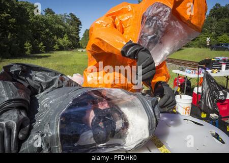 Un soldat de l'armée américaine avec le 21e Armes de Destruction-Civil Équipe de soutien (21e ADM-CST), New Jersey, coupe de la Garde nationale blessés simulés ouvert Le Sgt. Bercovic Joseph A. UN NIVEAU lors d'une combinaison de protection de l'armée chargé de l'évaluation de compétence formation à Naval Weapons Station Earle, Colts Neck, N.J., le 12 juin 2018. Le 21e-ADM TCPS appuie les autorités civiles lors de désastres naturels ou causés par l'homme en identifiant les substances chimiques, biologiques, radiologiques et nucléaires, ainsi que d'évaluer les conséquences, sur les mesures de riposte, conseille et aide à demander les forces de suivi. (New Jers Banque D'Images