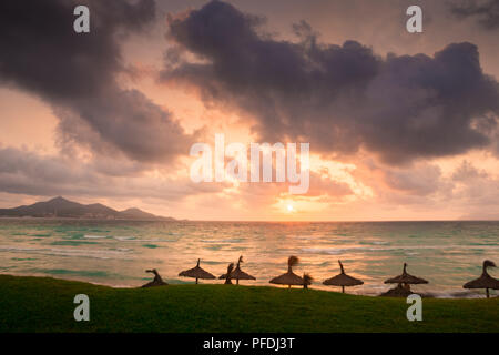 Majorque Puerto de Alcudia beach au lever du soleil dans la baie d'Alcudia à Majorque Îles Baléares de l'Espagne. Soleil se lève près de la montagne dans la mer. Banque D'Images