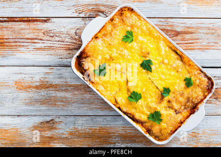 Délicieux la moussaka dans plat à gratin, recette authentique - couches d'aubergines, viande hachée, tomates, béchamel et fromage cuit au four décoré wi Banque D'Images