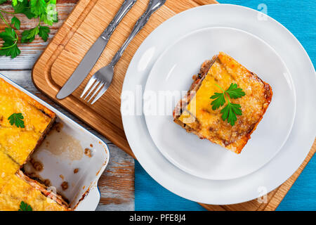 Partie de la moussaka délicieux décoré de persil cuit pour recette authentique, sur les plaques et dans le gratin de la peinture blanche, vue depuis l'ab conseils Banque D'Images