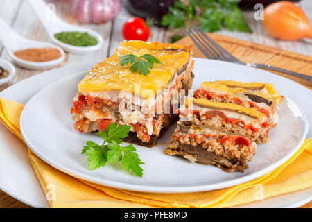 Partie de la moussaka délicieux décoré de persil cuit pour recette authentique, sur des plaques, sur les conseils de la peinture blanche Banque D'Images