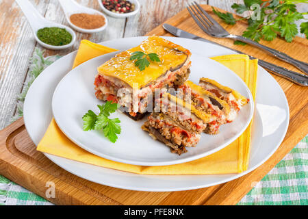 Partie de la moussaka délicieux décoré de persil cuit pour recette authentique, sur des plaques, sur les conseils de la peinture blanche, vue d'en haut Banque D'Images