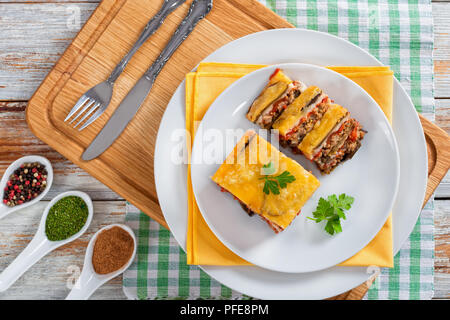 Partie de la moussaka délicieux décoré de persil cuit pour recette authentique, sur des plaques, sur les conseils de la peinture blanche, vue d'en haut Banque D'Images