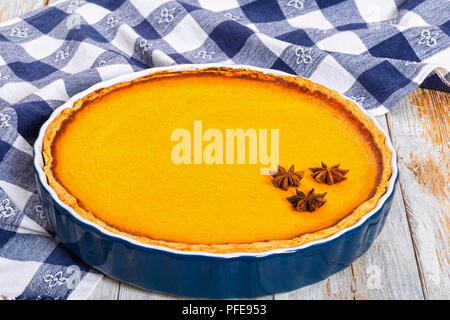 Delicious Fresh orange ronde décorée à la citrouille faits maison à l'anis étoile dans le plat de cuisson sur le tableau blanc avec cuisine recette authentique, serviette Banque D'Images