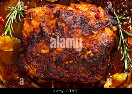 Ensemble de l'épaule de porc de rôti dans une rôtissoire avec la marinade chaude épicée riche et authentique, de romarin recette texas, vue de dessus, close-up Banque D'Images