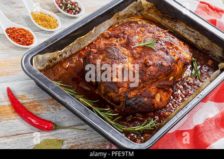 Gros morceau de viande Mijotés Oven-Barbecued l'épaule dans un plat à rôtir mariné aux épices, la sauce Worcestershire, le vinaigre de pomme, l'oignon et l'ail, vi Banque D'Images