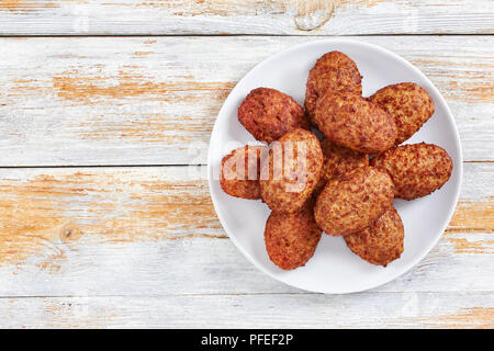 Escalopes de délicieux plats de viande juteuse sur plaque blanche sur de vieilles cartes de la peinture rustique, vue d'en haut Banque D'Images