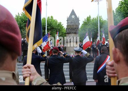 Le lieutenant-colonel Shane Fletcher (au centre, à gauche), commandant du bataillon de soutien de la Brigade, 3e Brigade Combat Team, 82e Division aéroportée, et les délégués français militaires durant l'hymne national américain lors d'une cérémonie à la 82nd Airborne Division Memorial Signal le 5 juin 2018 dans la ville de Sainte Mère Eglise, France. La cérémonie a été l'un des nombreux qui a célébré les parachutistes et les soldats qui se sont battus et ont libéré le peuple de France. Banque D'Images